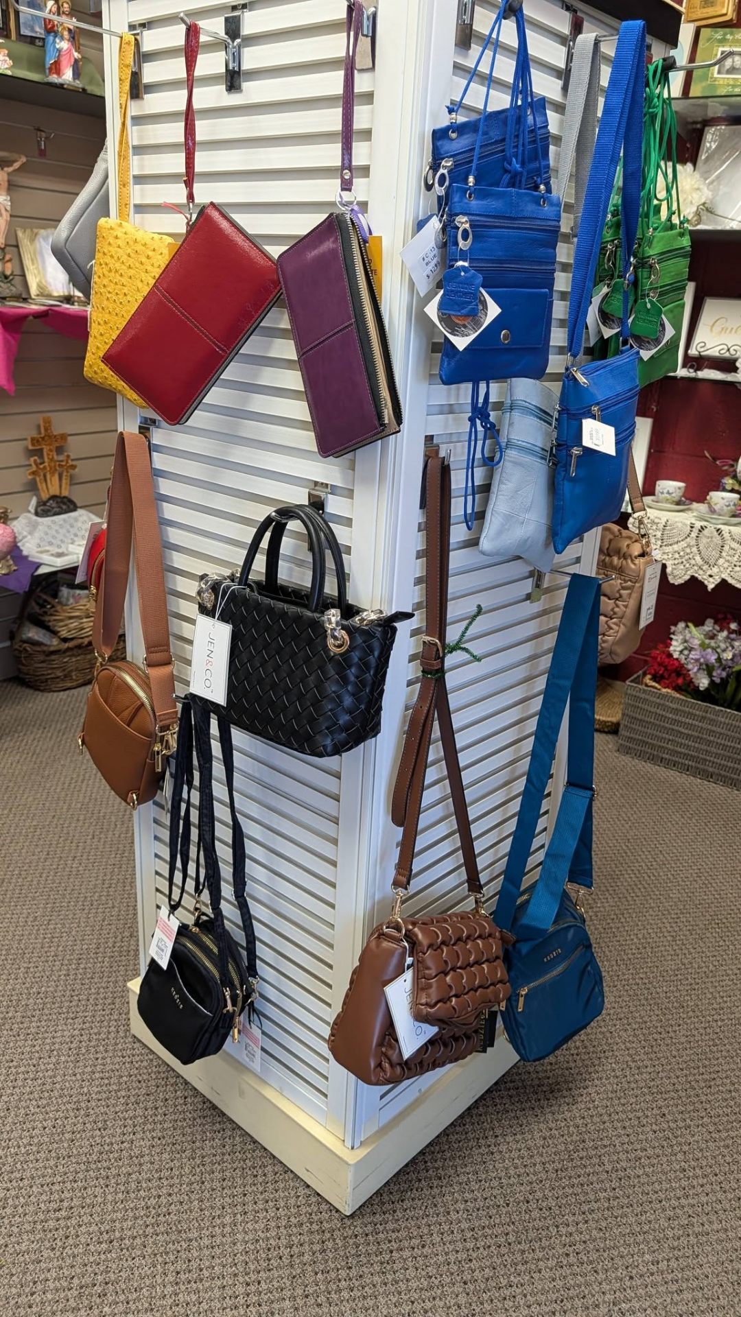 Colorful boutique handbags, wallets, and crossbody purses on display.