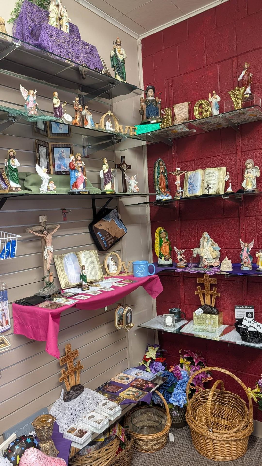 Wall display of saints, crucifixes, and Guadalupe figurines.